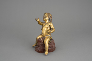 Lot 1132, Auction  121, Goldputto, Feuervergoldeter Bronzeputto auf Felsgestein aus ädrigem Rotmamor. 